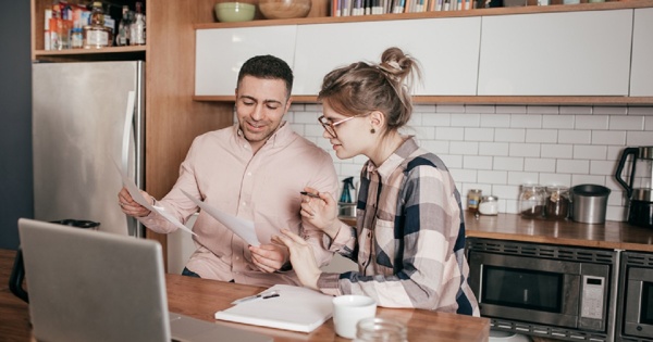 Couple discussing credit transfer in their kitchen at home